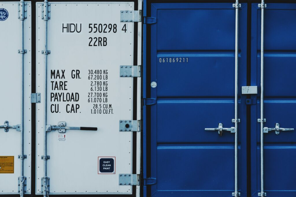 Pemasangan E-Seal atau segel kontainer elektronik pintar berbasis GPS pada pintu kontainer kargo untuk melacak keamanan dan posisi pengiriman barang secara real-time.